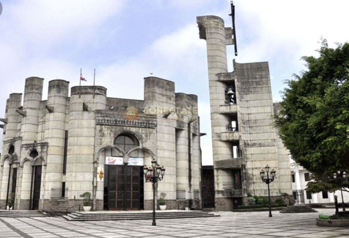 Un edificio grande e histórico con una entrada central en arco, múltiples torres cilíndricas y una bandera en la parte superior.