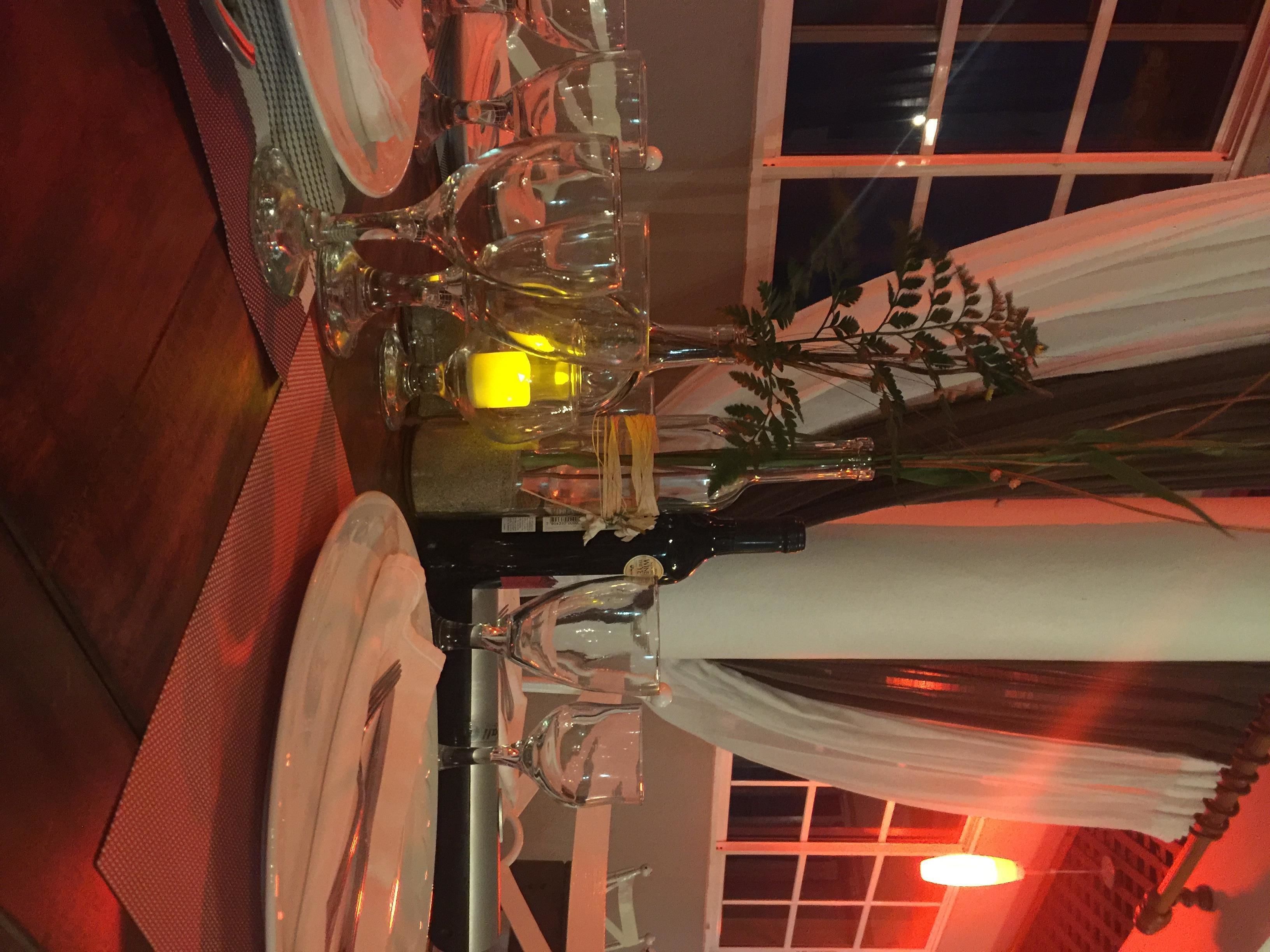 A dining table set with plates, glasses, and a candle.