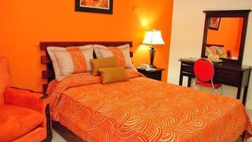Um quarto com uma cama, uma cadeira, um abajur e um espelho.