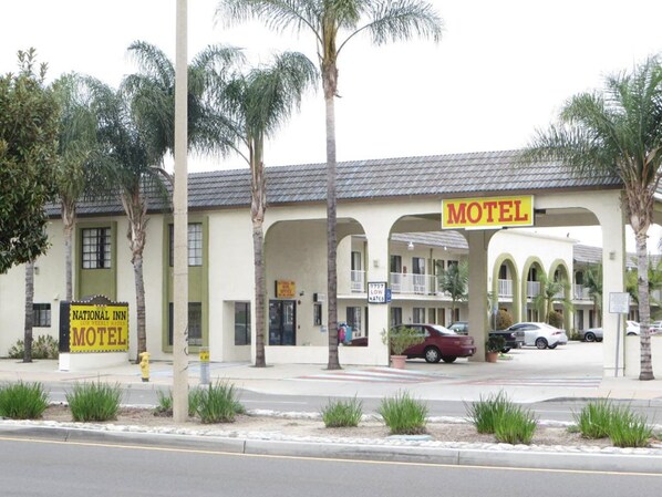 A motel with a signboard, a parking area, and a street view. - National Inn Garden Grove (Garden Grove)