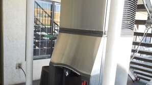 A commercial espresso machine with a digital display, a water reservoir, and a drip tray. - National Inn Garden Grove (Garden Grove)
