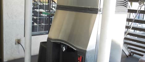 A commercial espresso machine with a digital display, a water reservoir, and a drip tray.