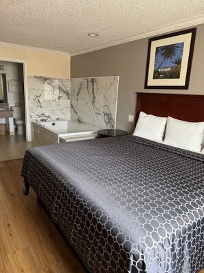 Habitación Deluxe, hidromasaje | Escritorio, tabla de planchar con plancha, wifi gratis y ropa de cama