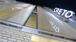 Fachada moderna de un edificio con un llamativo letrero 'CRETO'.