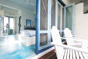 A room with a bed, a chair, and a door leading to another room. - Chanchalay Hip Hostel (Krabi)