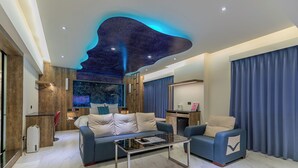 A modern living room with a sofa, armchair, and coffee table. - Lilai Travel - Lilia Motel (Taoyuan City)