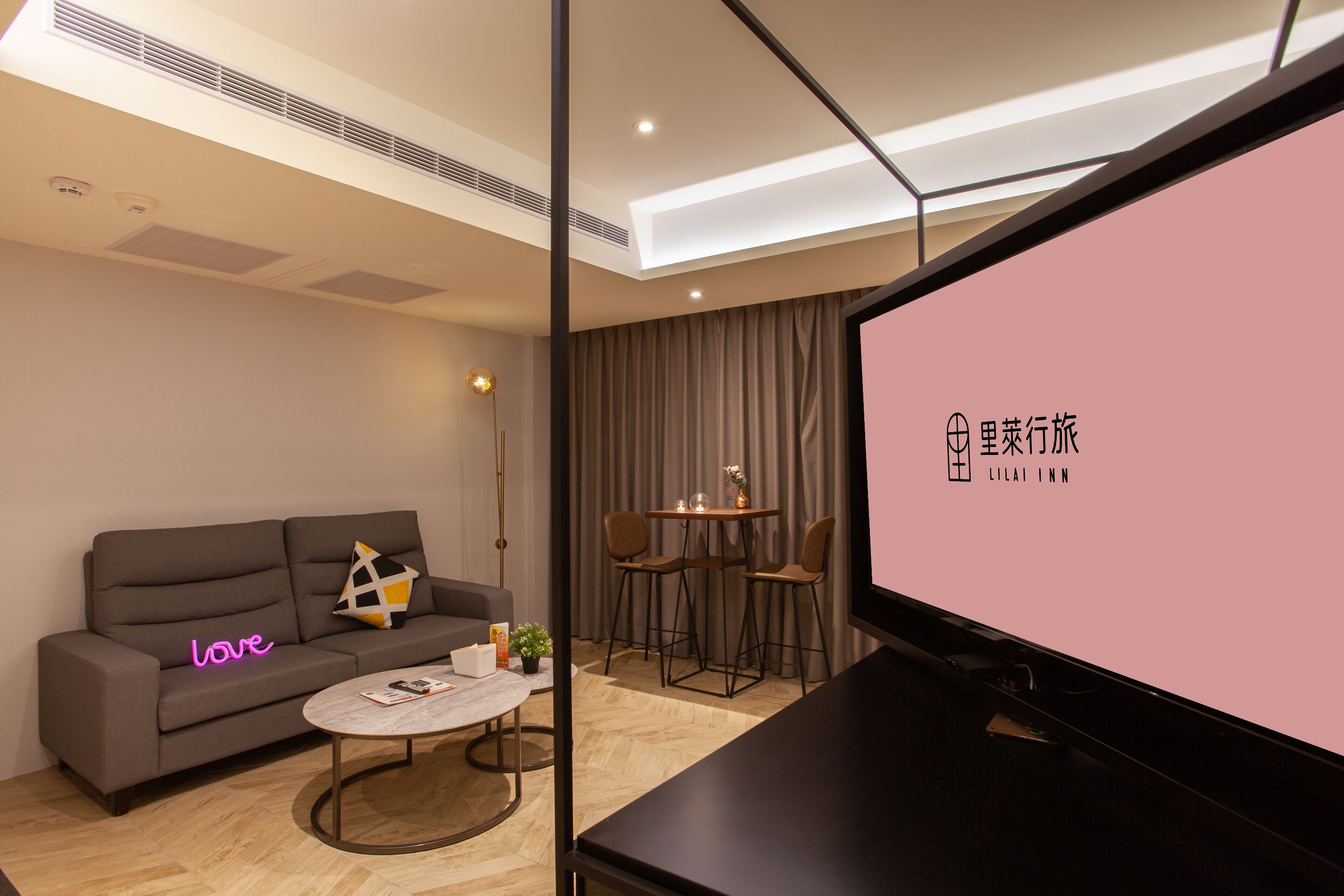 A modern living room with a sofa, coffee table, and a TV screen displaying text.