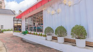 A building with large windows, potted plants, and a red awning. - Lilai Travel - Lilia Motel (Taoyuan City)