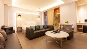 Una sala moderna con un sofá, una mesa redonda de centro y un comedor con una mesa y sillas.