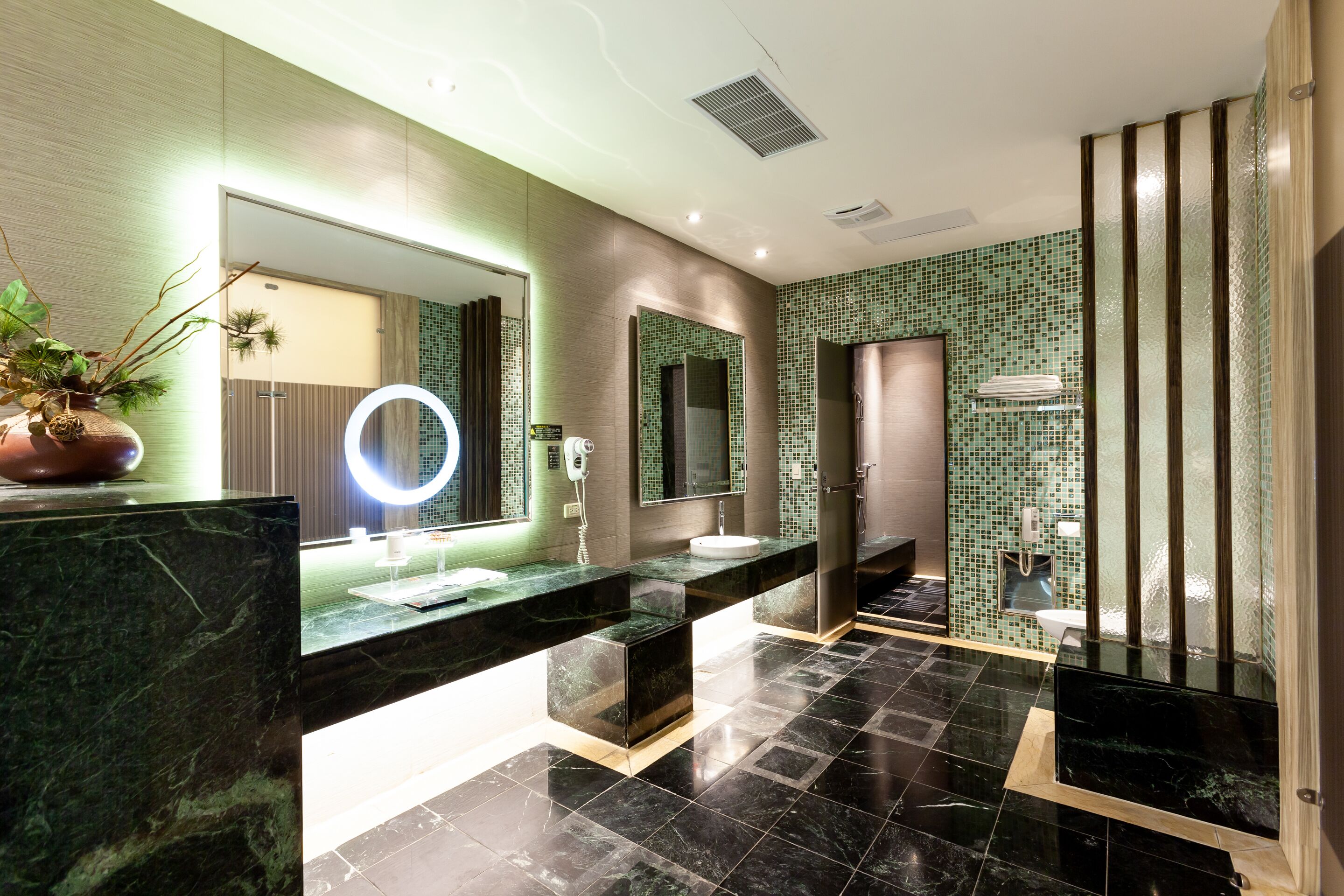 Un baño moderno con dos lavamanos, un espejo grande y zona de ducha.