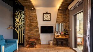 A modern living room with a flat-screen TV, a sofa, a coffee table, and a dining area with a chair and a small table. - Queen Love (Hualien City)