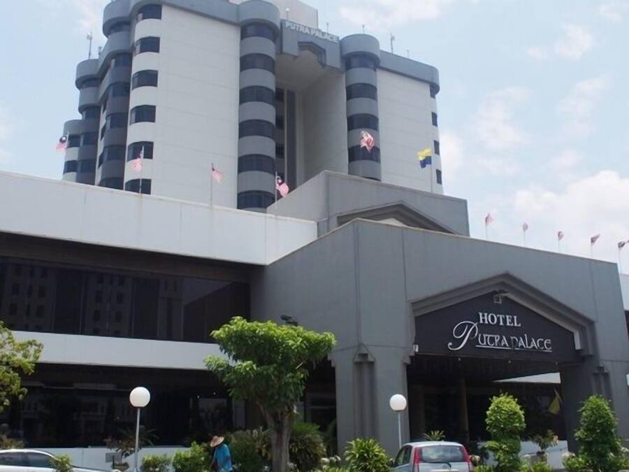 A modern hotel building with a prominent entrance labeled "HOTEL PUTRA PALACE".
