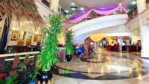 A spacious lobby with a central atrium, multiple floors, and a reception desk. - The Putra Regency Hotel (Kangar)