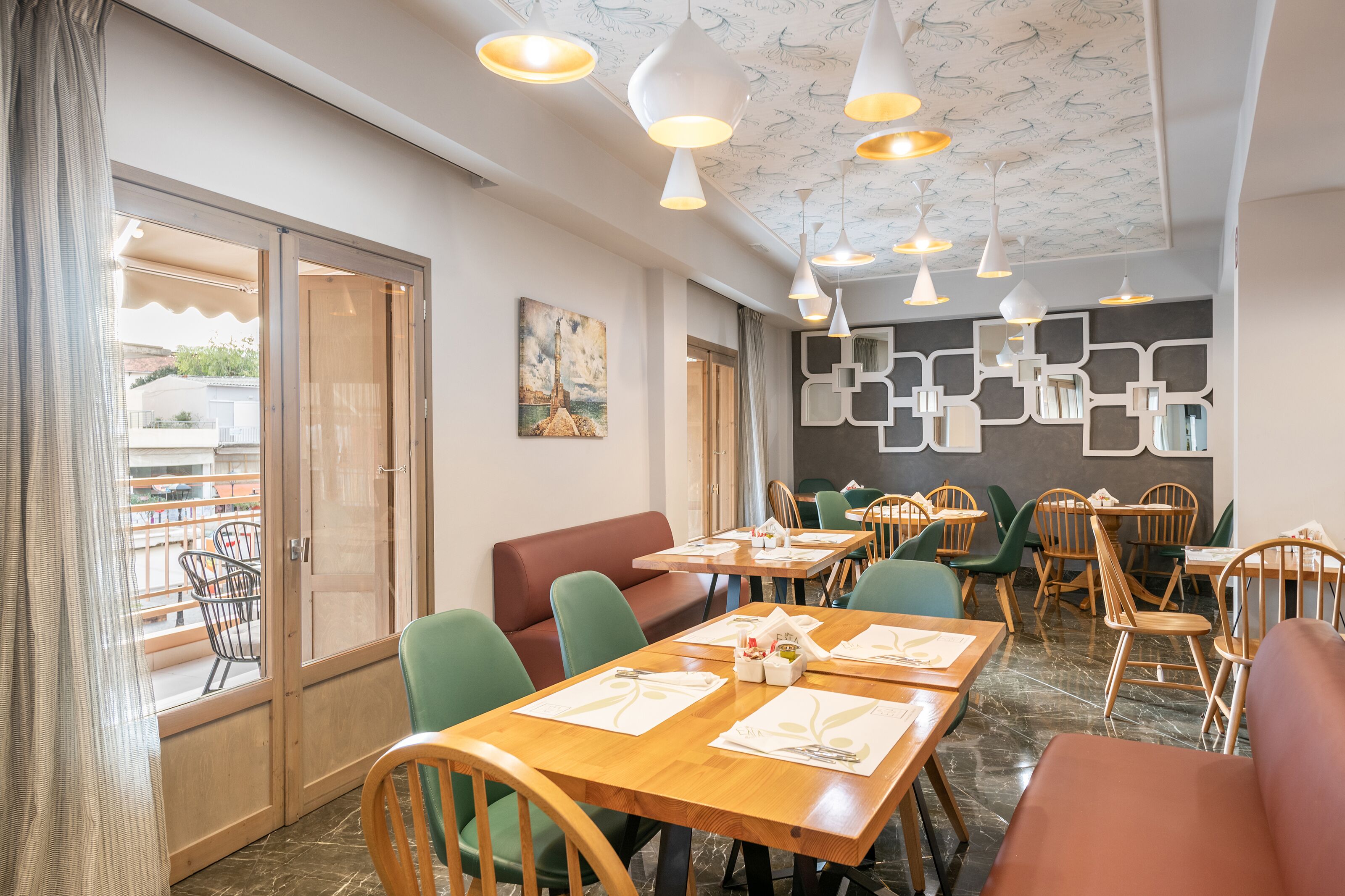 A restaurant with wooden tables, green and brown chairs, and pendant lighting.