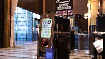 A currency exchange machine with multiple currency options and a sign indicating a money exchange service.