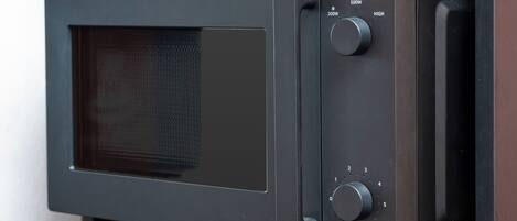 Een magnetron met een digitaal display en bedieningsknoppen.
