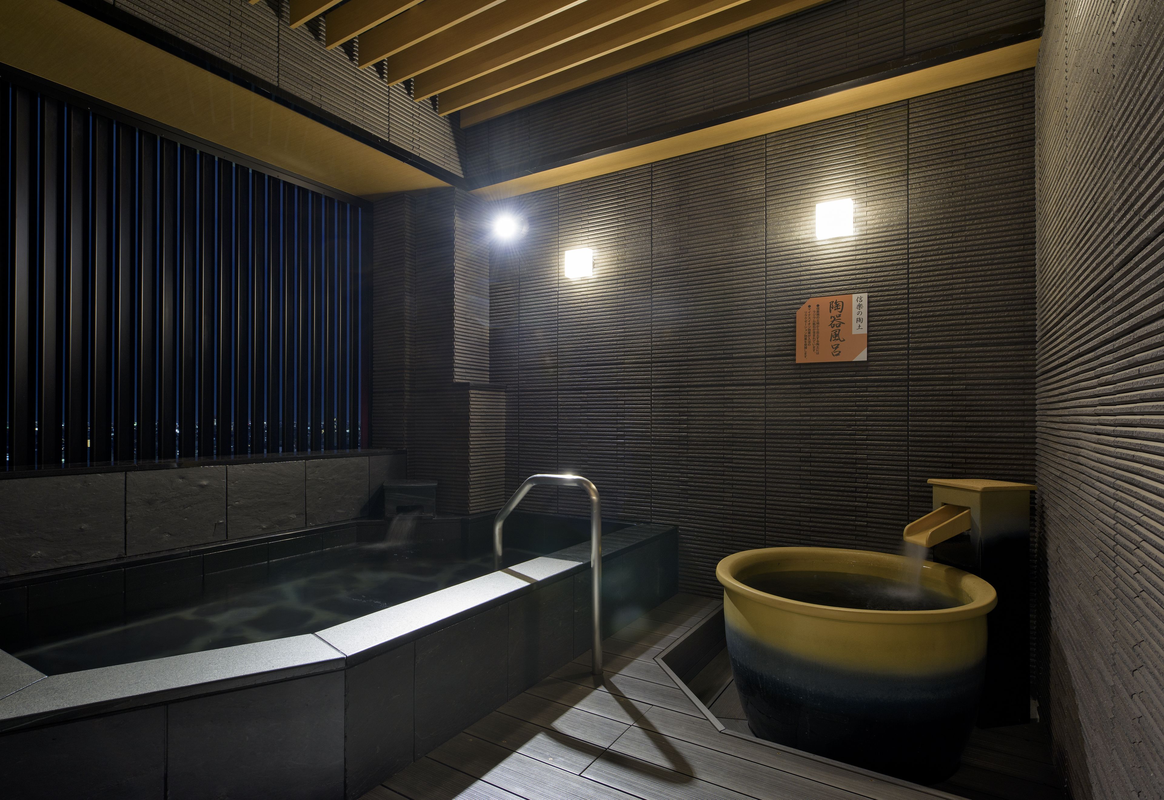 A modern bathroom with a large bathtub, a smaller hot tub, and a shower area.