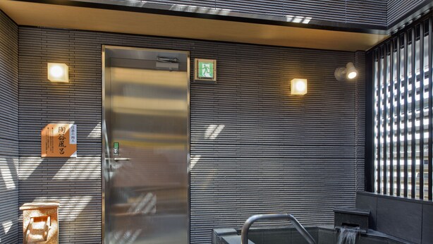 Uma área de spa moderna com hidromassagem, porta de vidro e placa fixada na parede.