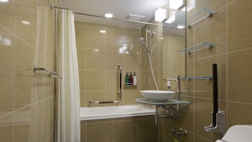 A modern bathroom with a bathtub, a glass-enclosed sink, and a shower area.