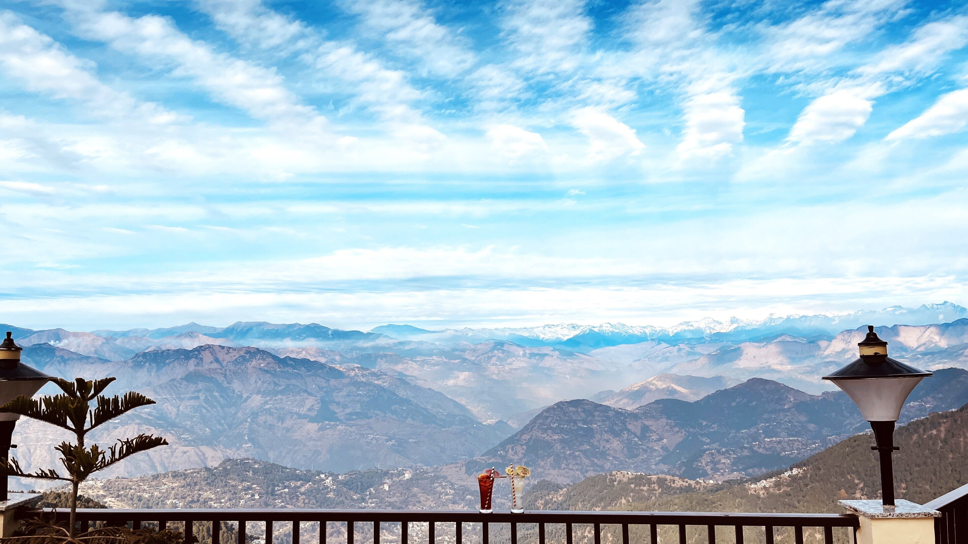A balcony with a view of snow-capped mountains and a clear sky.