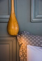 A wooden vase on a wall, a polka-dotted pillow, and a plain pillow.