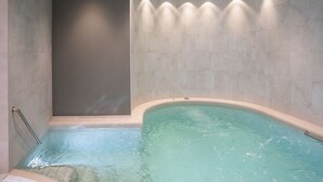 Un baño moderno con una bañera independiente, zona de ducha y pared con azulejos.