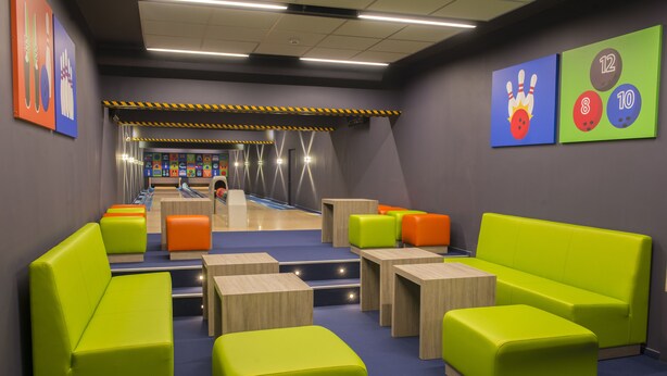 Een bowlingbaan met groene zitplaatsen en bowlingbanen.