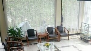 Un amplio salón con un conjunto de sofás, una mesa de centro y un televisor en la pared.
