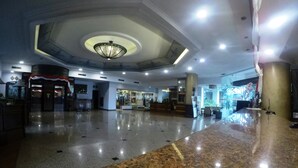 A spacious lobby with a polished granite floor, a central chandelier, and a reception desk. - Kedaton Hotel (Bandung)