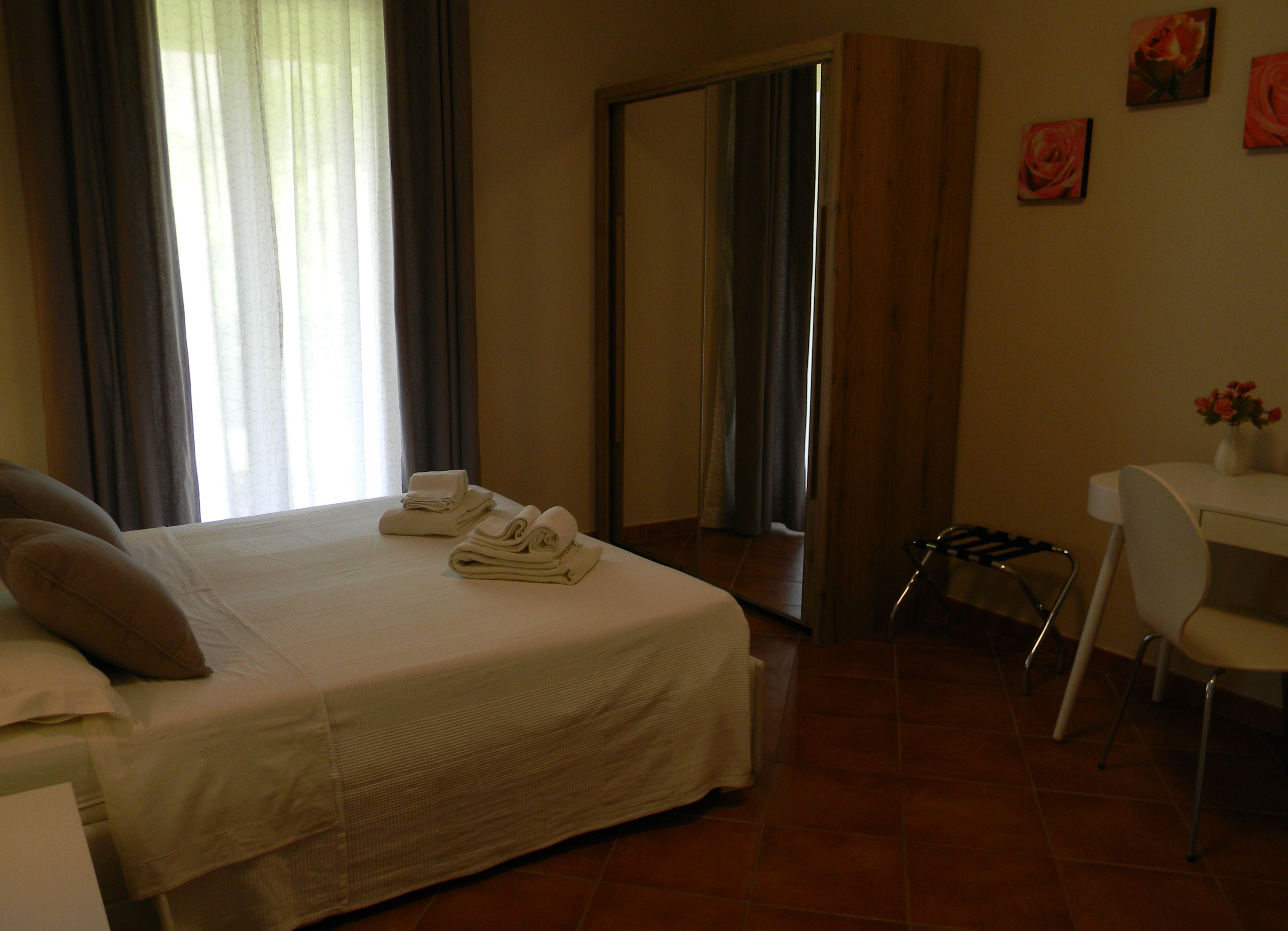 Ein Hotelzimmer mit Bett, Schreibtisch, Stuhl und Spiegel.