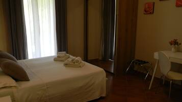 Ein Hotelzimmer mit Bett, Schreibtisch, Stuhl und Spiegel.