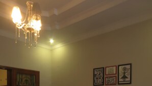 Un salón con una araña, dos sillones, un sofá y una mesa de centro.