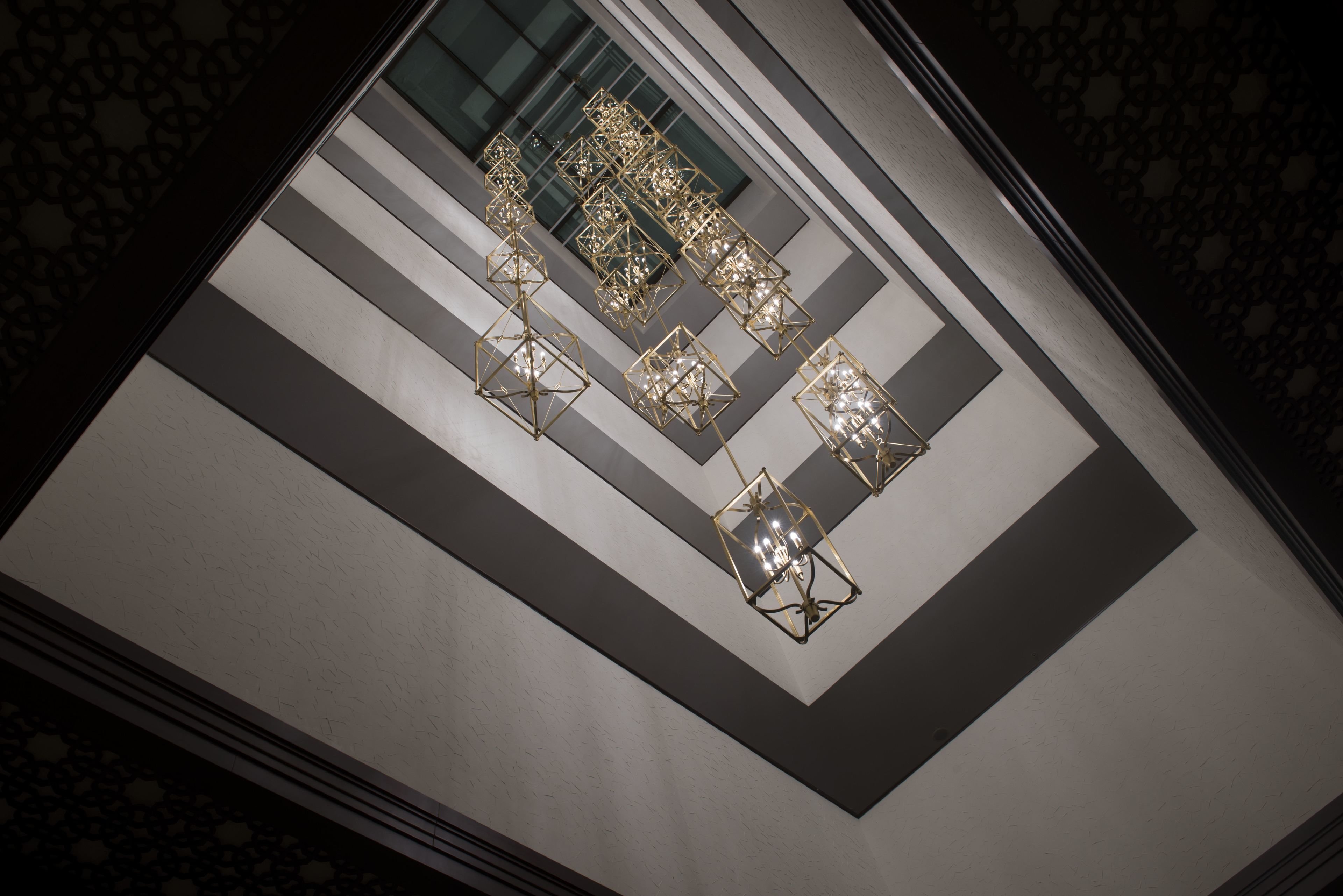 A modern interior with geometric light fixtures and a patterned floor.