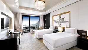 A modern hotel room with two beds, a desk, a TV, and a balcony with a view. - Shahdag Hotel & Spa (Qusar)