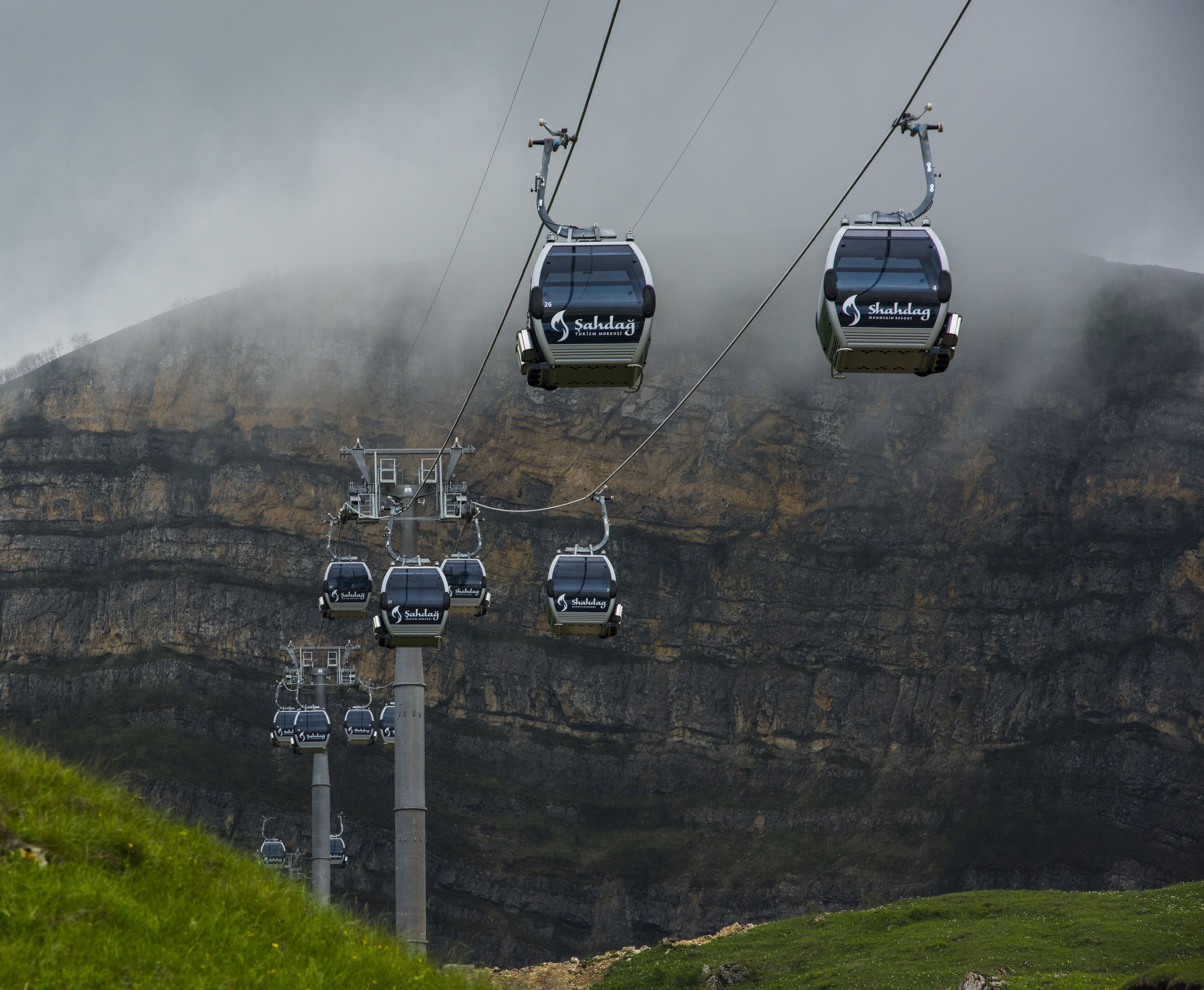 A cable car system with multiple cars ascending a mountain.