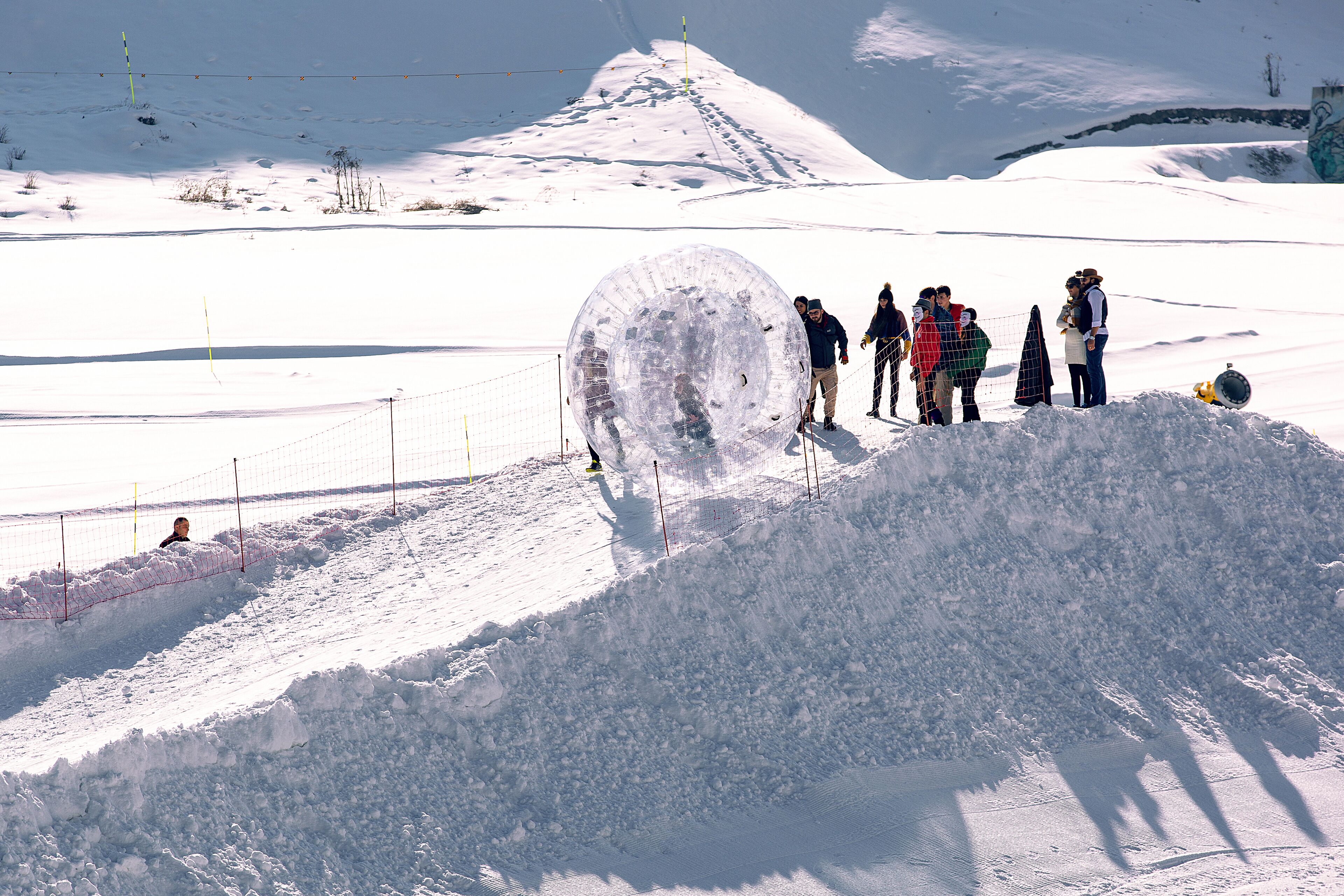 A snow-covered landscape with a group of people standing near a snow mound.