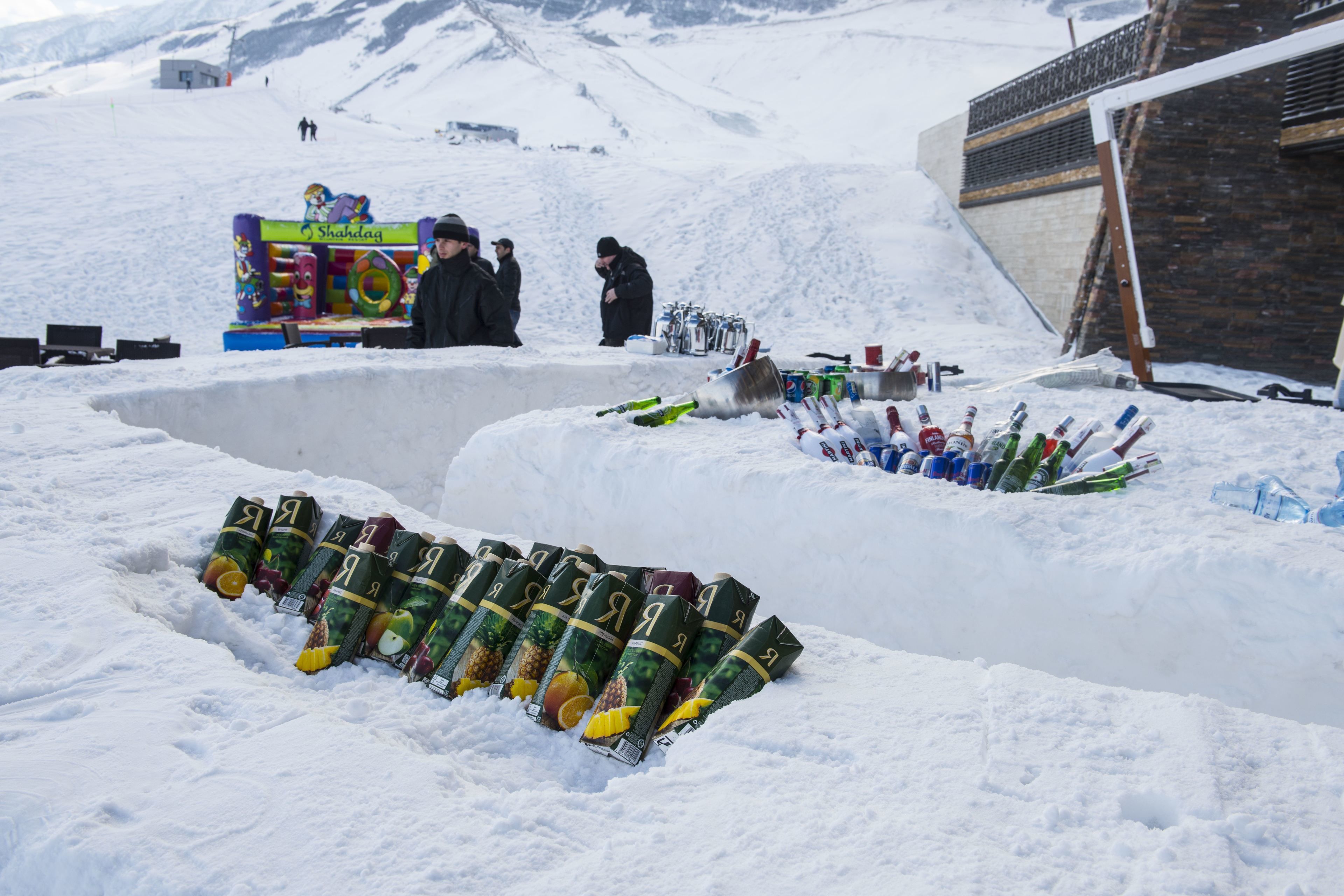 A snow-covered outdoor area with a vending machine and a pile of cans.