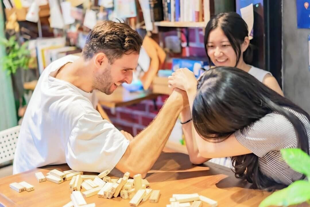 Un gruppo di persone gioca a un gioco da tavolo con pedine in legno su un tavolo.