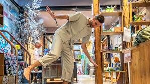 Una persona realizando una hazaña de equilibrio sobre un suelo con fechas e símbolos históricos.