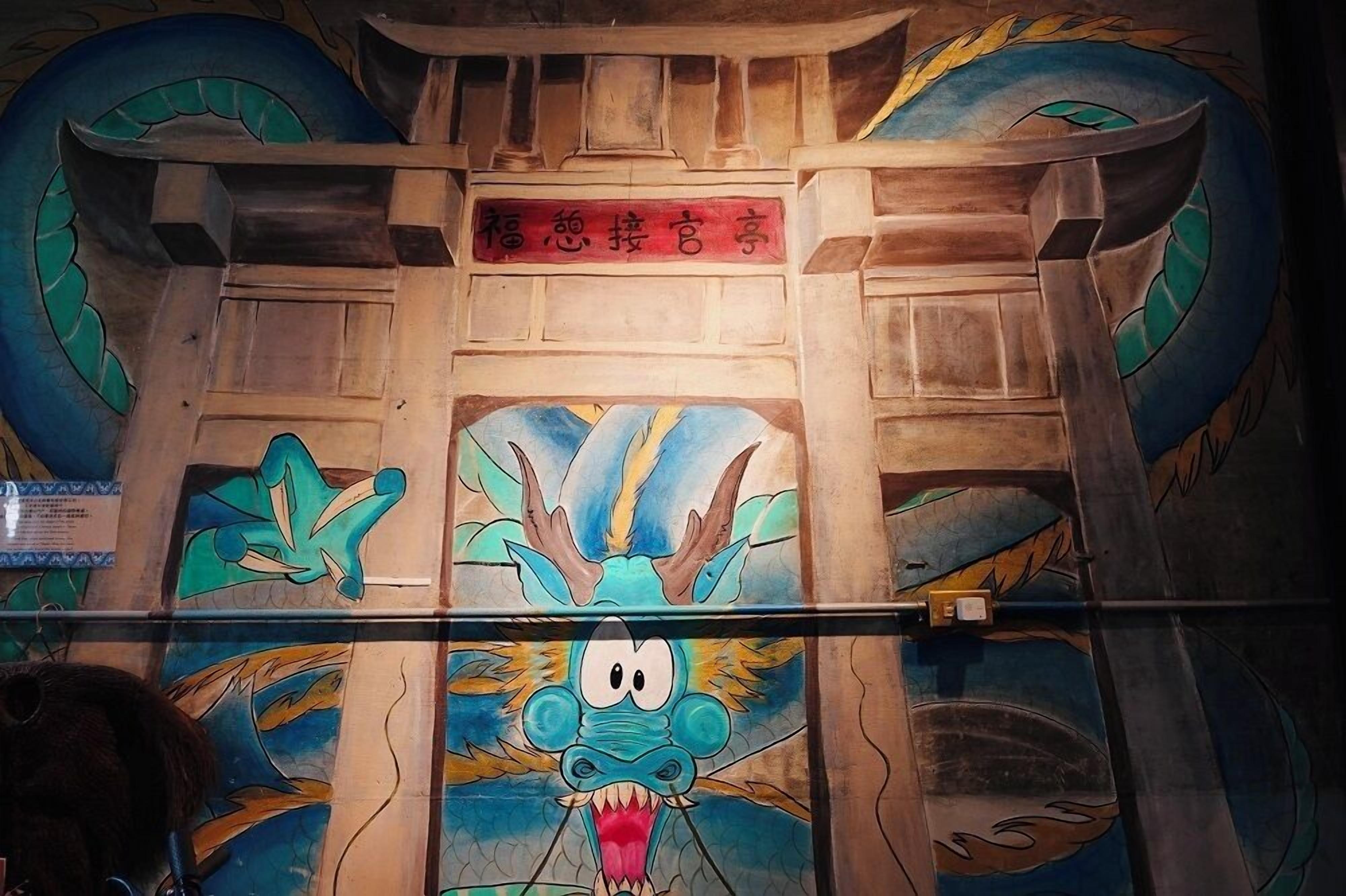 A room with a wooden ceiling and a large dragon mural.