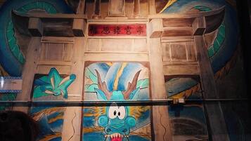 A room with a wooden ceiling and a large dragon mural.