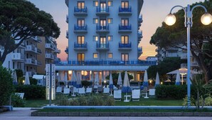 A hotel with multiple balconies, outdoor seating, and a well-maintained garden. - Hotel Croce di Malta (Jesolo)