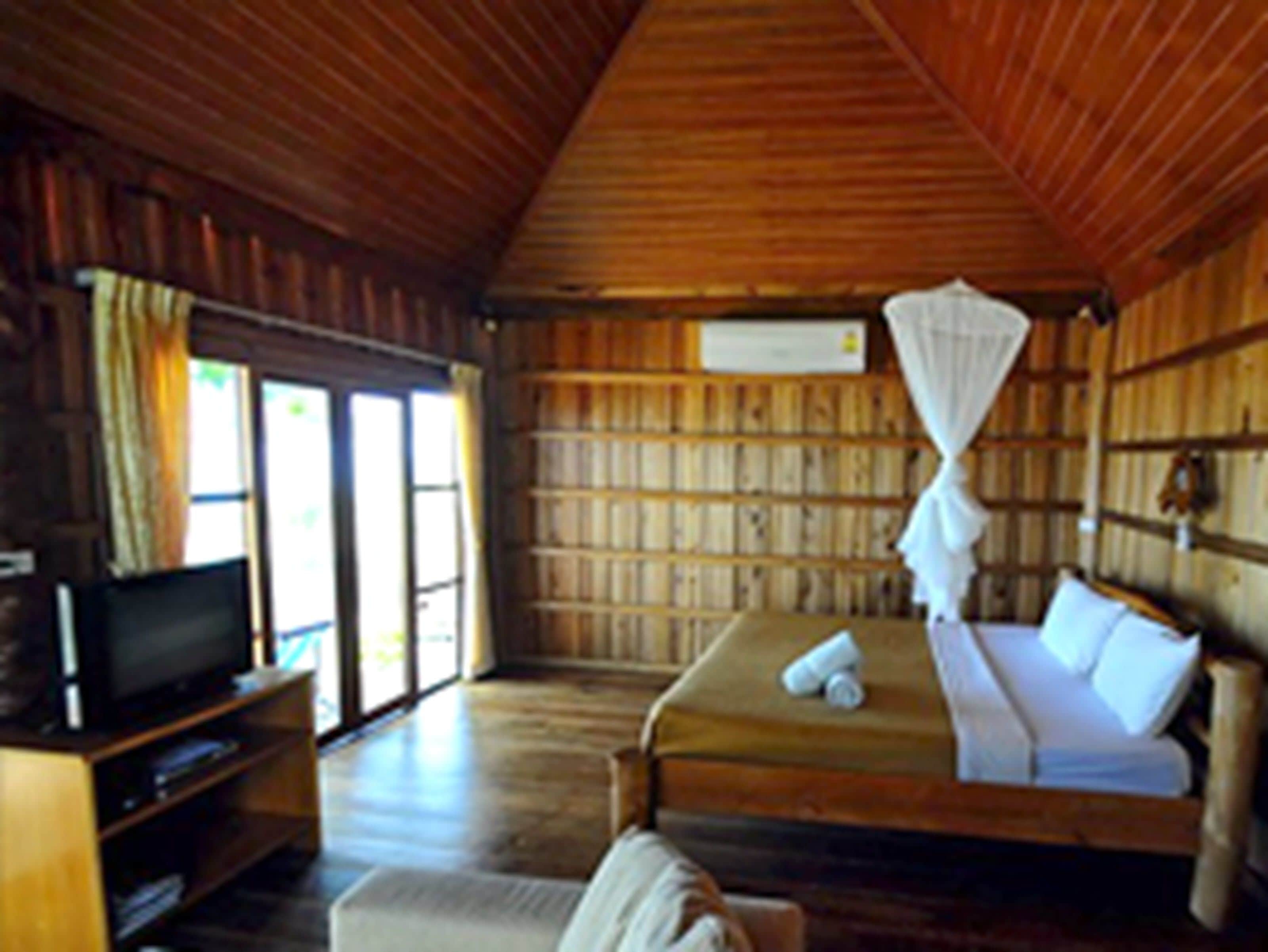 A room with a bed, a television, and a bookshelf.