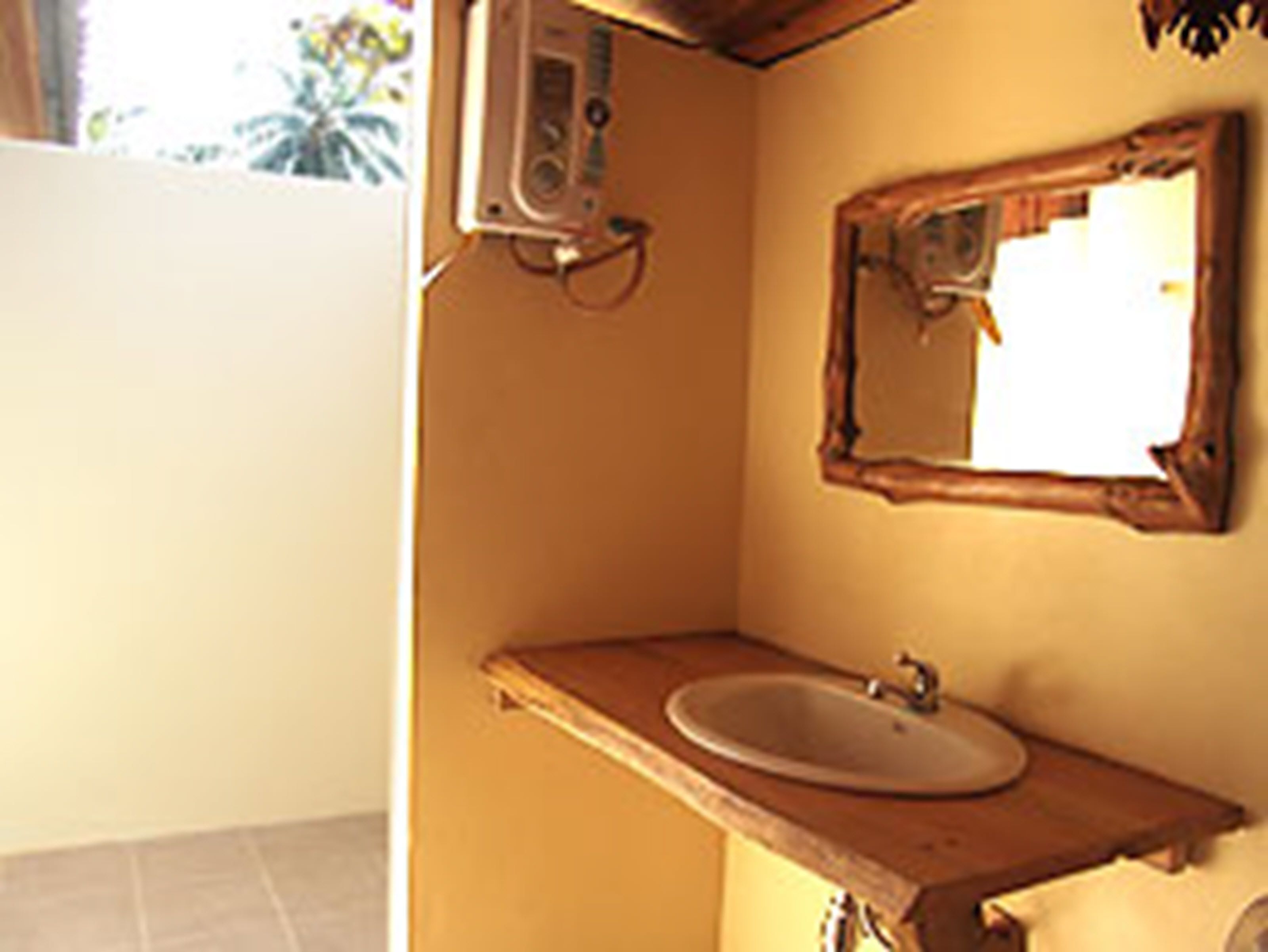 A bathroom with a wooden vanity, a sink, and a mirror.