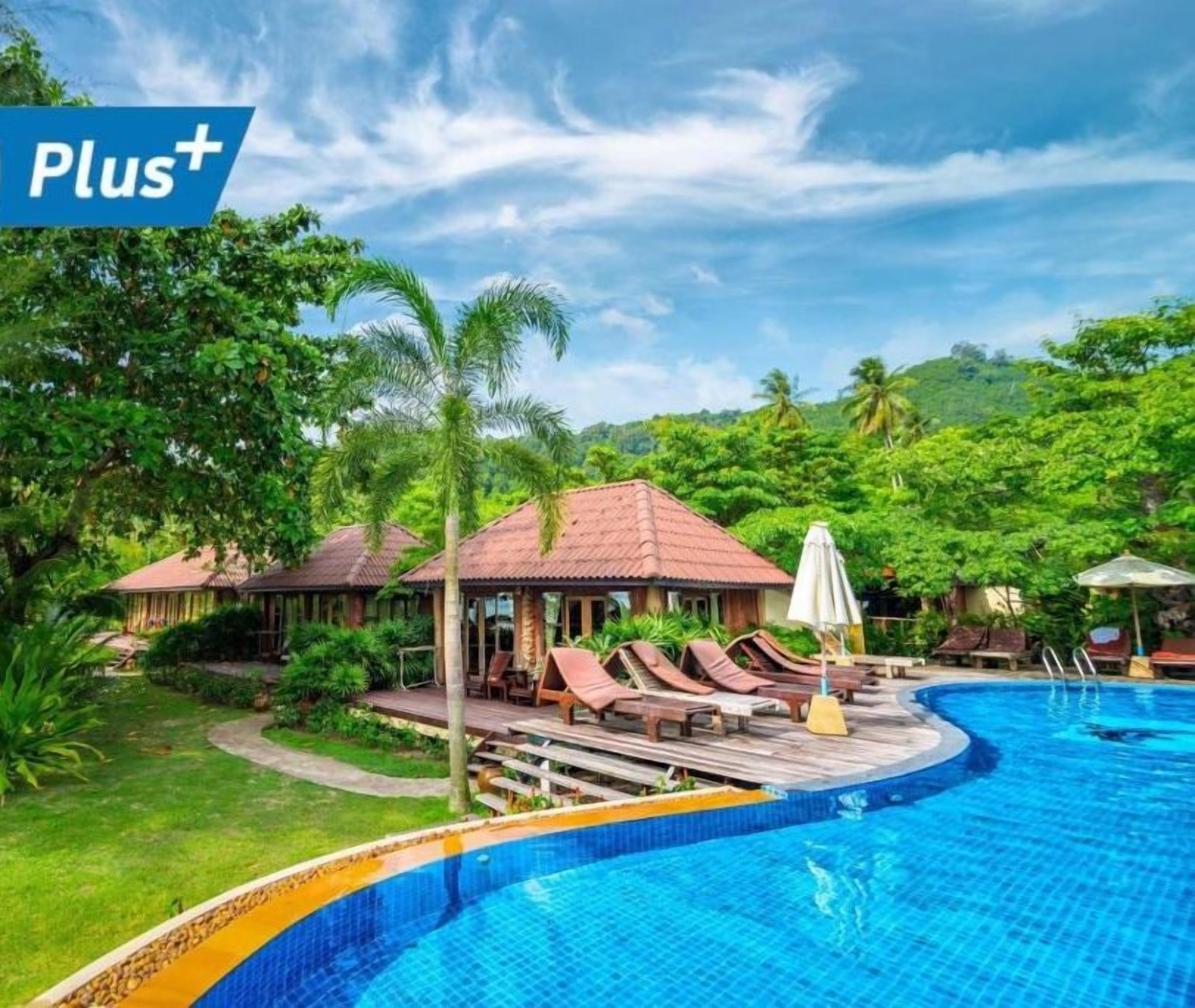A resort with a swimming pool, lounge chairs, and a gazebo.