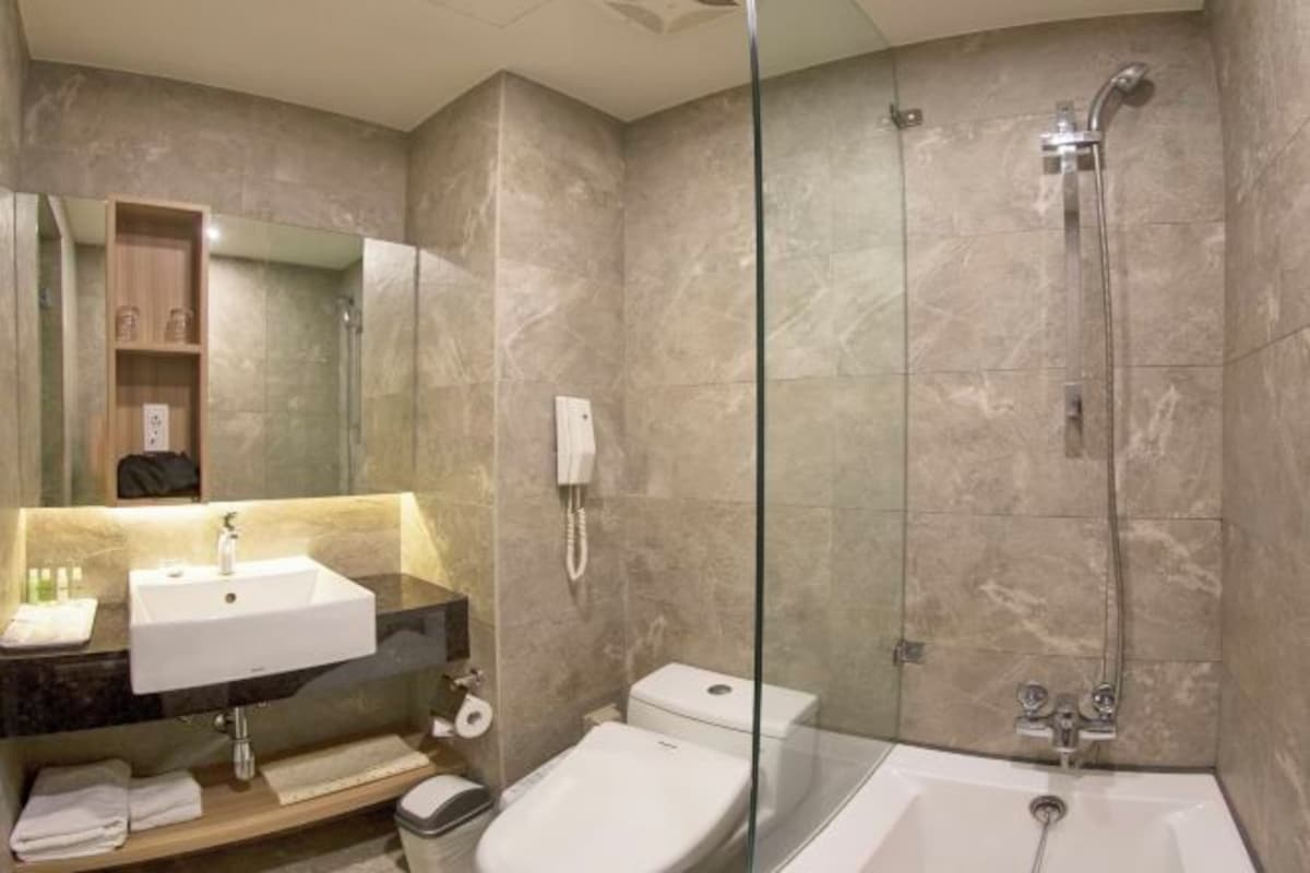Une salle de bain moderne avec une douche à parois de verre, un lavabo blanc et des toilettes.