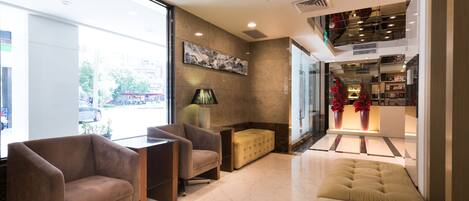Un vestíbulo moderno con un sofá, sillones y una mesa de centro.