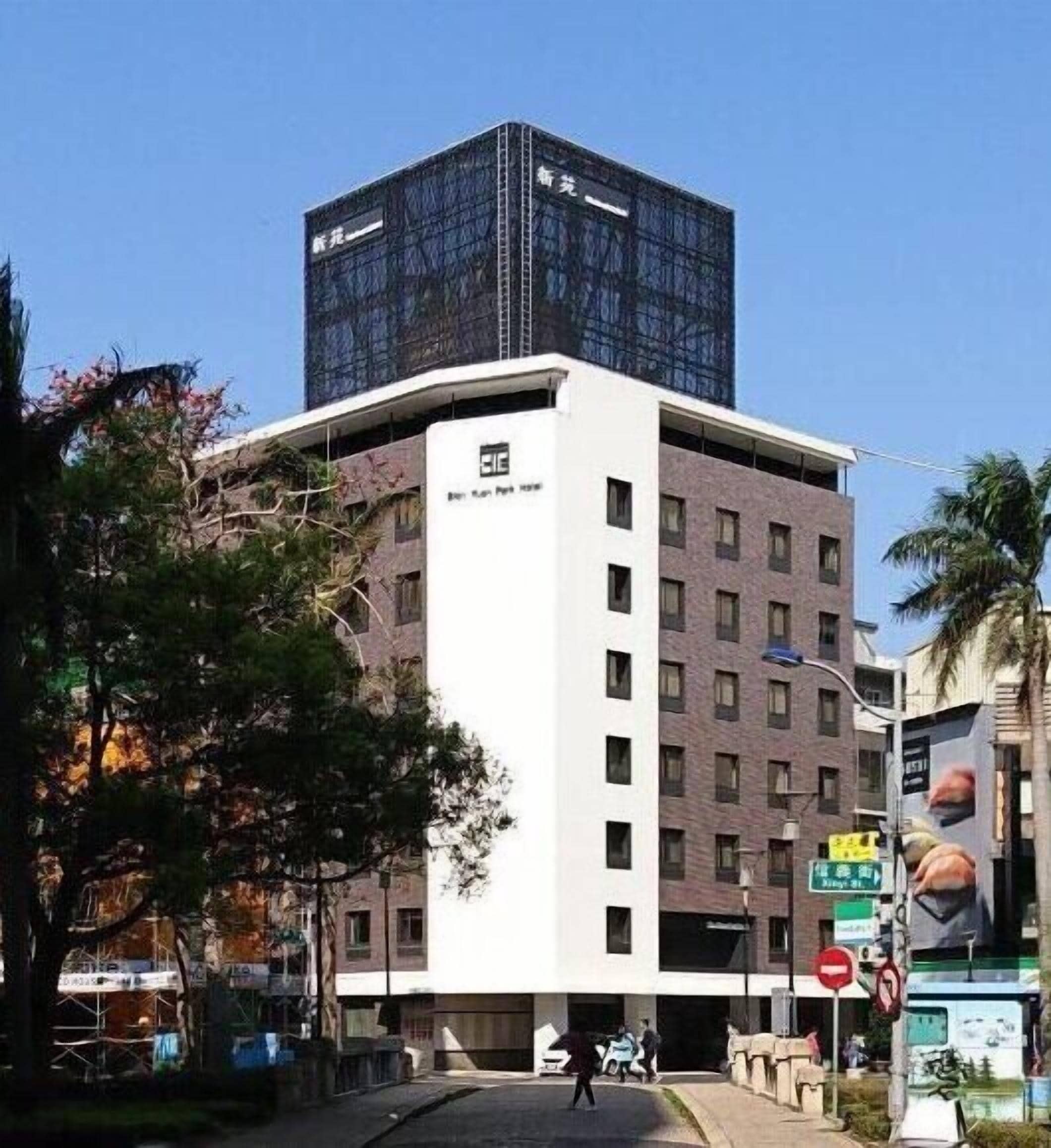 Un bâtiment moderne doté d’une façade en verre et d’une partie inférieure blanche.