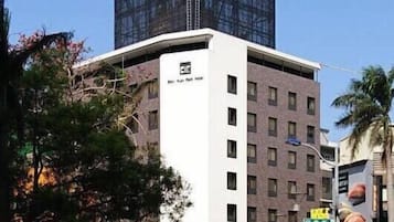Un bâtiment moderne doté d’une façade en verre et d’une partie inférieure blanche.