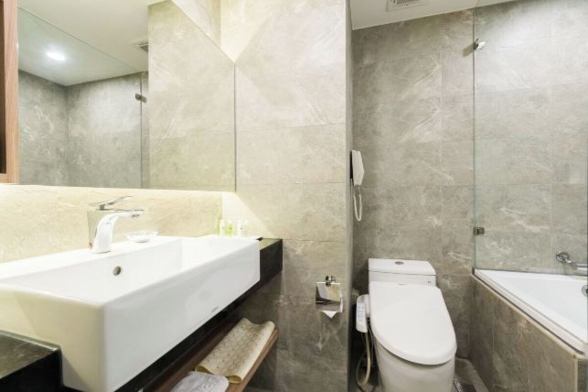 Une salle de bain moderne avec un grand lavabo, des toilettes et une baignoire.